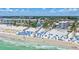 Beautiful aerial shot of a stunning, sandy beachfront resort with azure waters, beach umbrellas, and an abundance of tourists at 139 Vista Hermosa Circle, Sarasota, FL 34242