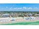 Overhead scene of a beautiful beachside resort with clear water, beach umbrellas, and a shoreline filled with happy tourists at 139 Vista Hermosa Circle, Sarasota, FL 34242