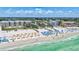 Scenic beach aerial showing tourists enjoying the sun on the shoreline with nearby beach resort buildings and clear ocean waters at 139 Vista Hermosa Circle, Sarasota, FL 34242