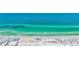 Breathtaking aerial shot of a beautiful sandy beach with crystal clear turquoise waters and abundant beach umbrellas at 139 Vista Hermosa Circle, Sarasota, FL 34242