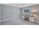 Bedroom with gray walls, white trim and ceiling fan features a wood desk with white cabinets under a window at 139 Vista Hermosa Circle, Sarasota, FL 34242