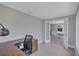 Office with wood desk, gray flooring and white trim connects to a dining area through double glass doors at 139 Vista Hermosa Circle, Sarasota, FL 34242