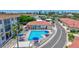 Aerial view of a community pool surrounded by buildings and blue umbrellas with tables and chairs at 139 Vista Hermosa Circle, Sarasota, FL 34242