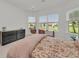 This bedroom features tiled flooring, a hanging swing chair, and multiple large windows at 15315 Derna Ter, Bradenton, FL 34211