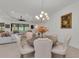 Dining room with chandelier, table and upholstered chairs, with view into living area at 15315 Derna Ter, Bradenton, FL 34211