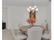 Dining room featuring a round table with upholstered chairs, a chandelier, and artwork at 15315 Derna Ter, Bradenton, FL 34211