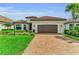 Charming home featuring a well-manicured lawn, brick driveway, and a two-car garage at 15315 Derna Ter, Bradenton, FL 34211