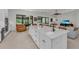 Modern kitchen with a large white island, stainless appliances, and an open floorplan flowing to living area at 15315 Derna Ter, Bradenton, FL 34211