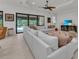 Bright and airy living room with a large sectional sofa, ceiling fan, and access to a pool at 15315 Derna Ter, Bradenton, FL 34211