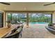 Screened-in patio features a dining area and comfortable seating with views of the pool and backyard at 15315 Derna Ter, Bradenton, FL 34211