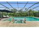 Screened in pool with integrated hot tub and decorative landscape lighting on a neutral stone deck at 15315 Derna Ter, Bradenton, FL 34211