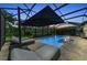 Relaxing pool area with lounge chairs and an umbrella, enclosed in a screened patio at 15315 Derna Ter, Bradenton, FL 34211