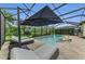 Screened pool with connected hot tub, sun lounger area and shade umbrella under a screened lanai at 15315 Derna Ter, Bradenton, FL 34211