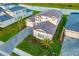 Aerial view showcasing a home's layout, three-car garage, paver driveway, and lush landscaping at 17128 Ranchside Pl, Lakewood Ranch, FL 34211