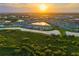 Panoramic aerial view of a planned community featuring lush landscaping and multiple ponds at sunset at 17128 Ranchside Pl, Lakewood Ranch, FL 34211