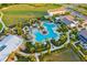 Aerial view of a stunning community pool and amenities area, featuring lush landscaping, lounge chairs, and a modern clubhouse at 17128 Ranchside Pl, Lakewood Ranch, FL 34211