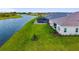 Aerial view of a backyard with a large grass area and a view of the lake at 17128 Ranchside Pl, Lakewood Ranch, FL 34211