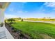 Green backyard featuring a water view surrounded by various foliage and a perfectly manicured lawn at 17128 Ranchside Pl, Lakewood Ranch, FL 34211