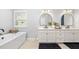 Bright bathroom with a soaking tub, double vanity, modern fixtures, and plantation shutters at 17128 Ranchside Pl, Lakewood Ranch, FL 34211