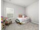 Cozy bedroom featuring a comfortable bed, chair, and natural light streaming through the window at 17128 Ranchside Pl, Lakewood Ranch, FL 34211
