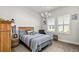 Comfortable bedroom with neutral walls, a bed, and window with light streaming in at 17128 Ranchside Pl, Lakewood Ranch, FL 34211