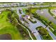 Aerial view of a gated community entrance featuring lush landscaping, palm trees, and a serene pond at 17128 Ranchside Pl, Lakewood Ranch, FL 34211