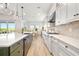 Modern kitchen features bright white cabinetry, stainless appliances, a large island, and a view to the outdoors at 17128 Ranchside Pl, Lakewood Ranch, FL 34211