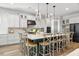Spacious kitchen featuring a large center island with seating, modern appliances, and stylish pendant lighting at 17128 Ranchside Pl, Lakewood Ranch, FL 34211
