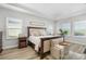 Bright and airy main bedroom featuring a large bed, tray ceiling, and plantation shutters at 17128 Ranchside Pl, Lakewood Ranch, FL 34211