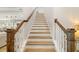 Staircase with wood treads and white risers leads to upper level of home at 17128 Ranchside Pl, Lakewood Ranch, FL 34211