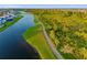 Scenic aerial view of a lakeside walking path surrounded by lush greenery and waterfront views at 17128 Ranchside Pl, Lakewood Ranch, FL 34211