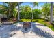 Secluded backyard with a fire pit, stylish pavers, lush greenery, and well-maintained landscaping at 1871 Prospect St, Sarasota, FL 34239