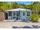 Charming home featuring a light green exterior and screened-in porch with seating at 1871 Prospect St, Sarasota, FL 34239