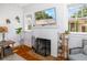 Cozy living room featuring a white brick fireplace with mounted TV and warm hardwood floors at 1871 Prospect St, Sarasota, FL 34239