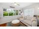 Sun-filled living room features large window overlooking a garden and relaxed seating arrangements at 1871 Prospect St, Sarasota, FL 34239