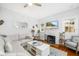 Bright living room with white brick fireplace, hardwood floors, and comfortable furnishings at 1871 Prospect St, Sarasota, FL 34239