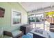 Cozy screened porch featuring comfortable seating, a fire pit table, and mounted television at 1871 Prospect St, Sarasota, FL 34239