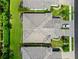 An aerial view shows the gray shingled roof of the home, green lawns, and a paver driveway with a parked silver SUV at 2070 Crystal Lake Trl, Bradenton, FL 34211