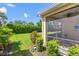 View of the screened patio from the backyard showcasing lush green landscaping and blue skies at 2070 Crystal Lake Trl, Bradenton, FL 34211