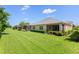 Expansive backyard featuring a well-maintained lawn, screened patio, and lush green landscaping at 2070 Crystal Lake Trl, Bradenton, FL 34211