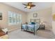 Well-lit bedroom with a decorative iron bed frame, neutral walls, and a ceiling fan at 2070 Crystal Lake Trl, Bradenton, FL 34211