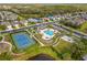 Aerial view of community pool, tennis court, and lush landscaping create a resort-like atmosphere at 2070 Crystal Lake Trl, Bradenton, FL 34211
