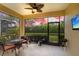 Relaxing screened patio with ceiling fan and outdoor seating overlooking the lush landscaping at 2070 Crystal Lake Trl, Bradenton, FL 34211