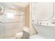 Bright bathroom with tiled shower, glass door, and stacked washer/dryer for convenient laundry access at 2310 Gulf N Dr # 104, Bradenton Beach, FL 34217