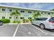 Exterior view of Shell Cove condos showing the building's facade, parking and tropical landscaping at 2310 Gulf N Dr # 104, Bradenton Beach, FL 34217