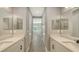 Stylish bathroom featuring double sinks, a neutral palette, and a well-lit space leading to other rooms at 2321 Blue Mahoe Ln, Sarasota, FL 34240