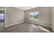 Bright bedroom with a large window showcasing lush outdoor scenery and stylish, light-colored floors at 2321 Blue Mahoe Ln, Sarasota, FL 34240