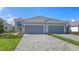 Beautiful home exterior with a two-car garage, paver driveway, and neatly manicured landscaping at 2321 Blue Mahoe Ln, Sarasota, FL 34240