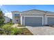 Charming home with a two-car garage, paver driveway, and vibrant, manicured landscaping at 2321 Blue Mahoe Ln, Sarasota, FL 34240