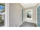 Cozy front porch with a tiled floor, light gray walls, and a blue front door at 2321 Blue Mahoe Ln, Sarasota, FL 34240